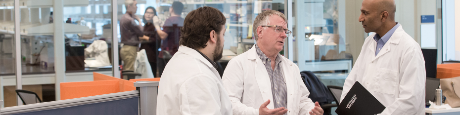 Brett Johnson, Ph.D., (left) Gordon Mills, M.D., Ph.D., and Joshi Alumkal, M.D., in one of the shared laboratory areas within the Knight Cancer Research Building. 