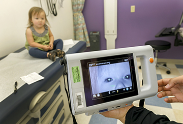 A toddler gets screened with the latest technology to check for vision problems.