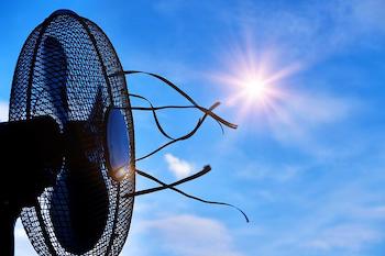 Image of a fan in front of a blue sky and bright sun