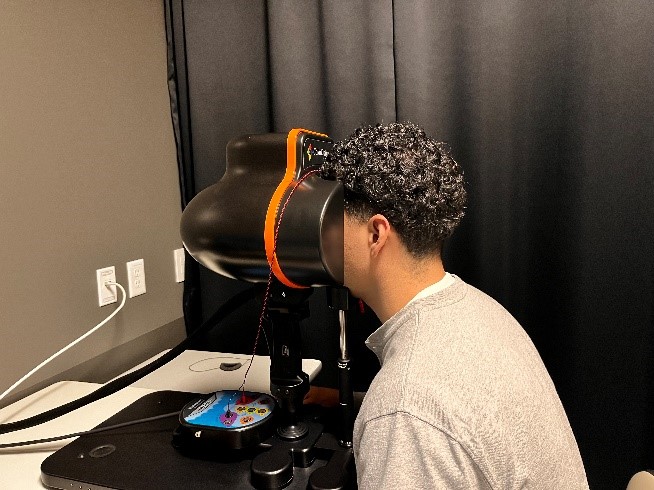 Man sits with the front of his face in a black machine.