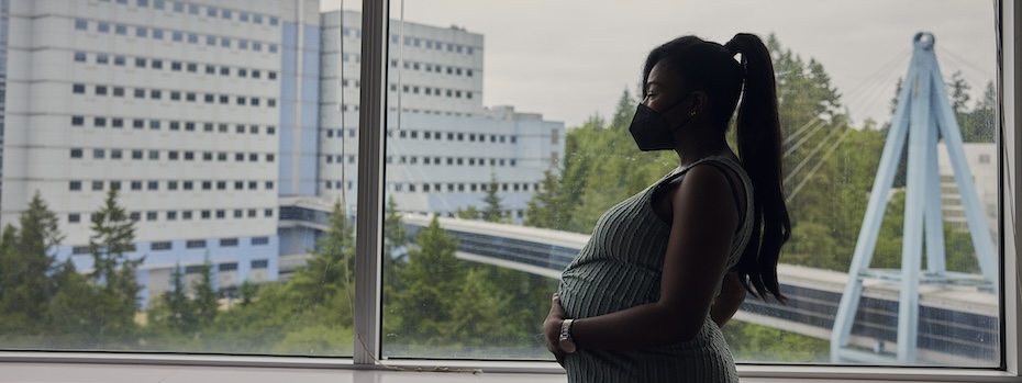 A pregnant patient looks out a window at OHSU.