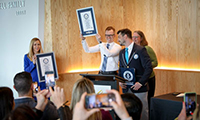 A researcher holds up an award at a press conference at OHSU.