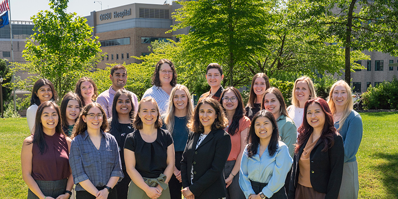The PGY-1 Pediatric Residency Class standing outside with OHSU Hospital behind them on a sunny day.