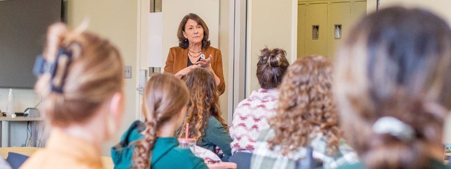 A nursing faculty member teaches to students in a classroom setting.