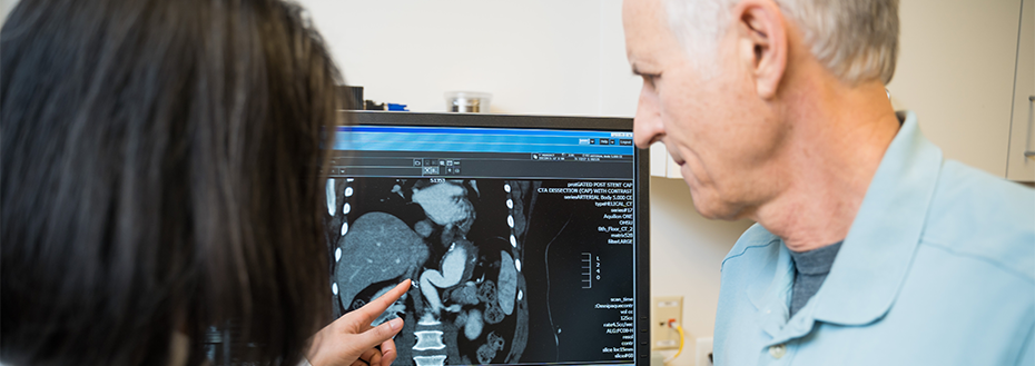 Dr. Jung goes over a vascular imaging study on a computer screen with her patient.