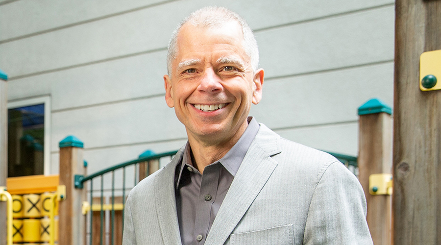 A photo of Joel Nigg, Ph.D. standing in a playground.