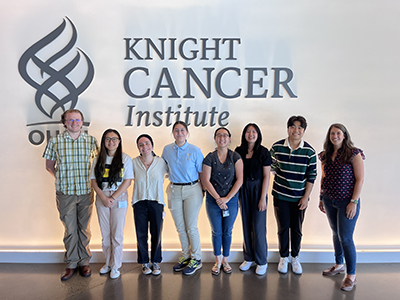 Eight people in front of a Knight Institute sign.