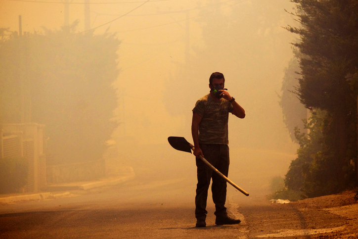 Person working on a smoky street.