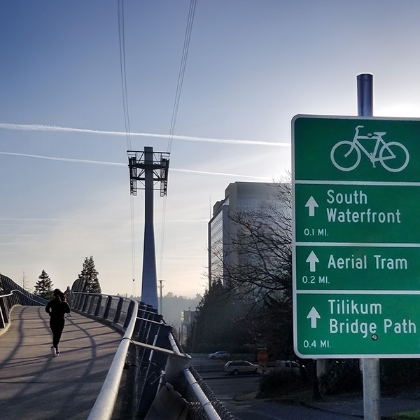 a person jogs Hooley Bridge toward the Tram tower