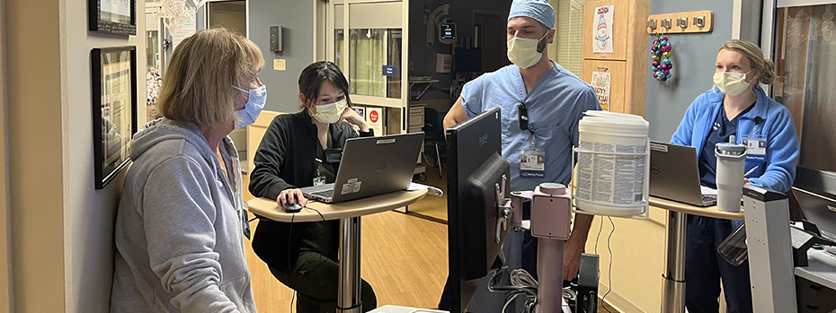 Four members of the NSICU team gathered in the unit along with equipment