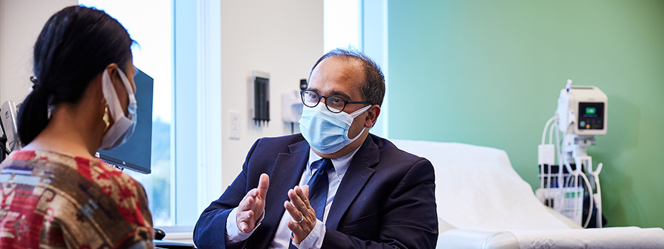 OHSU surgeon Flavio Rocha meets with a patient in an exam room.