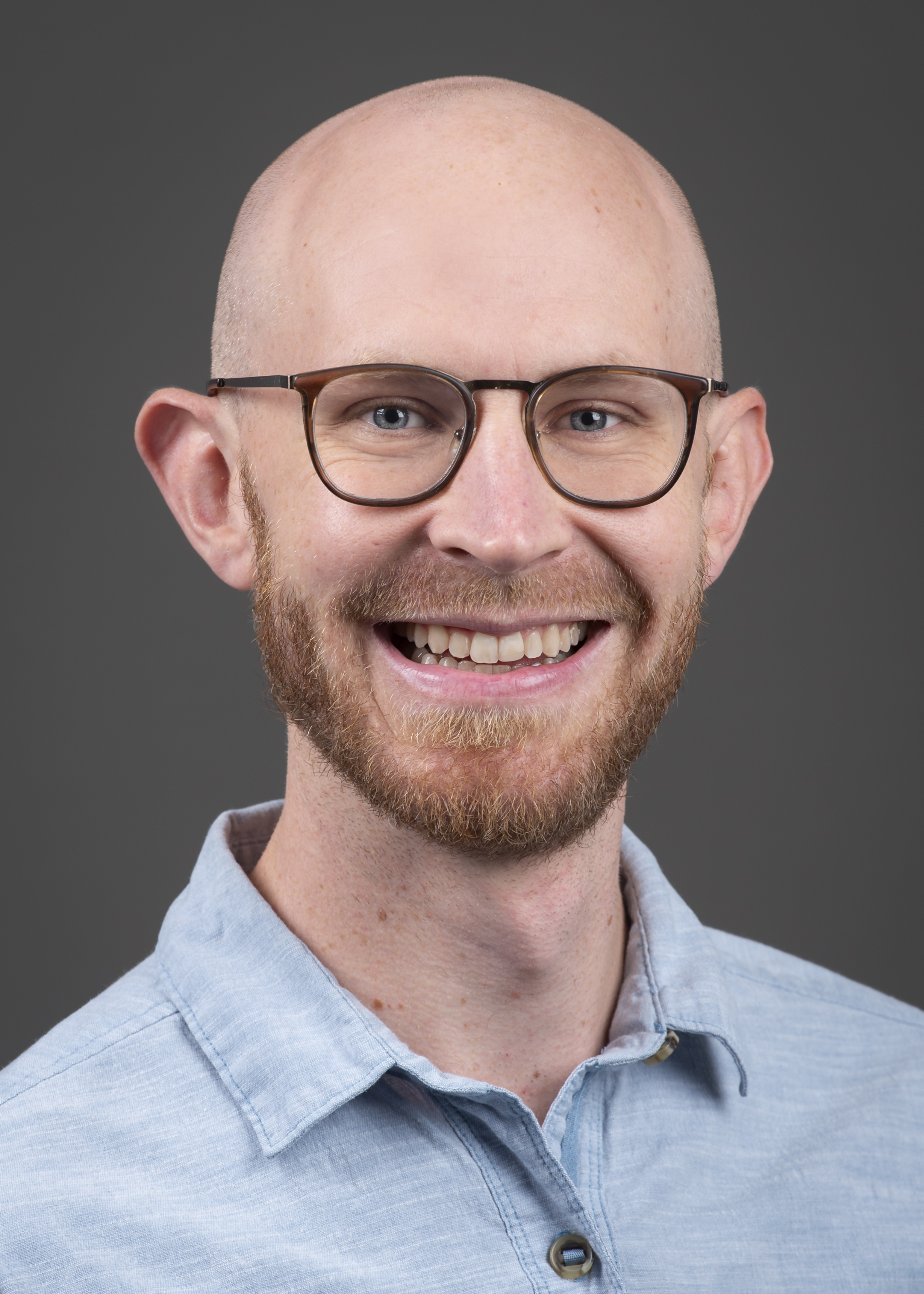 Profile photo of person smiling and wearing a blue collar shirt