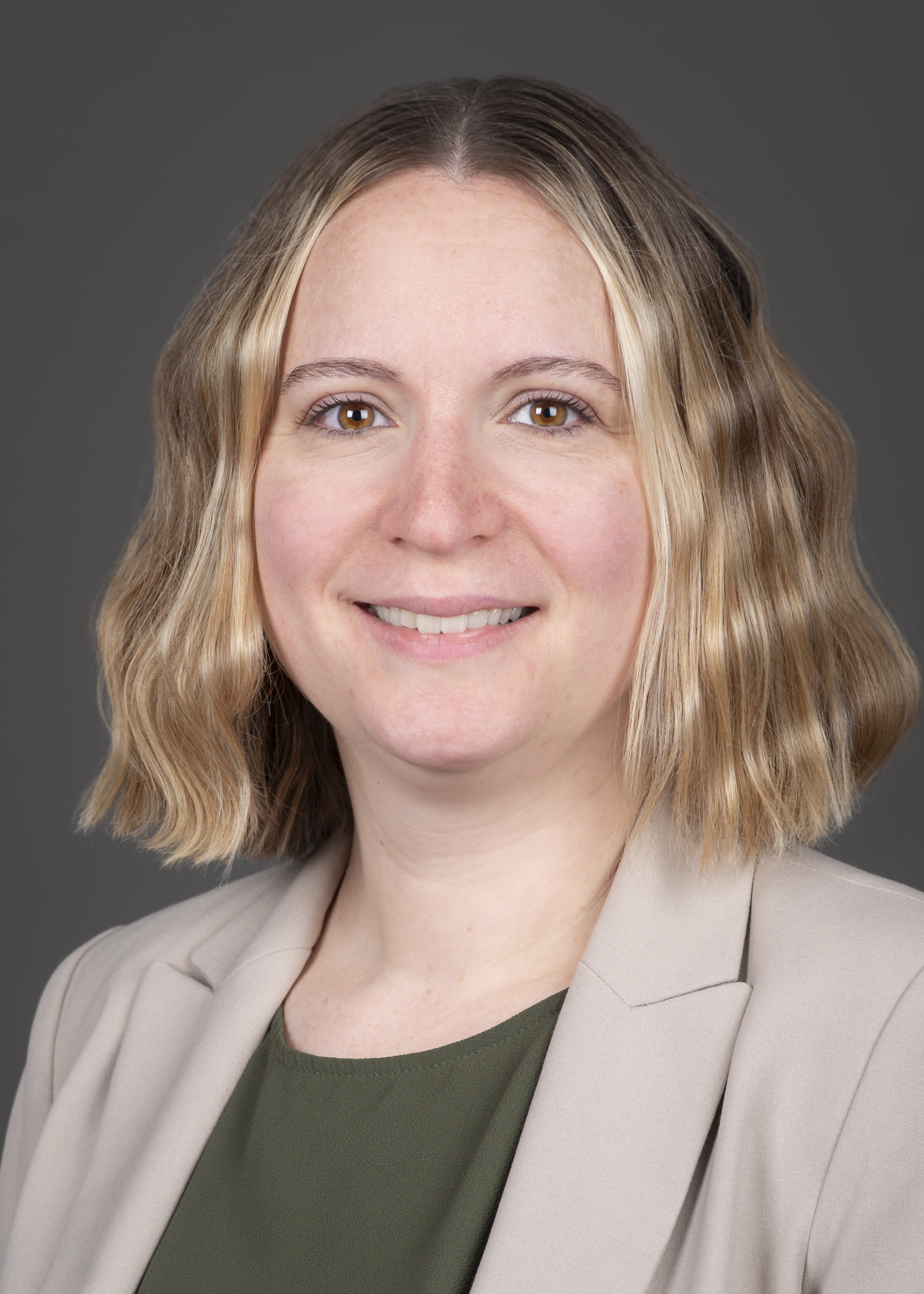 Profile photo of person smiling and wearing a blazer 