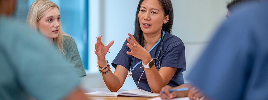 OHSU School of Nursing students sit around a table in a classroom, collaborating during a learning session.