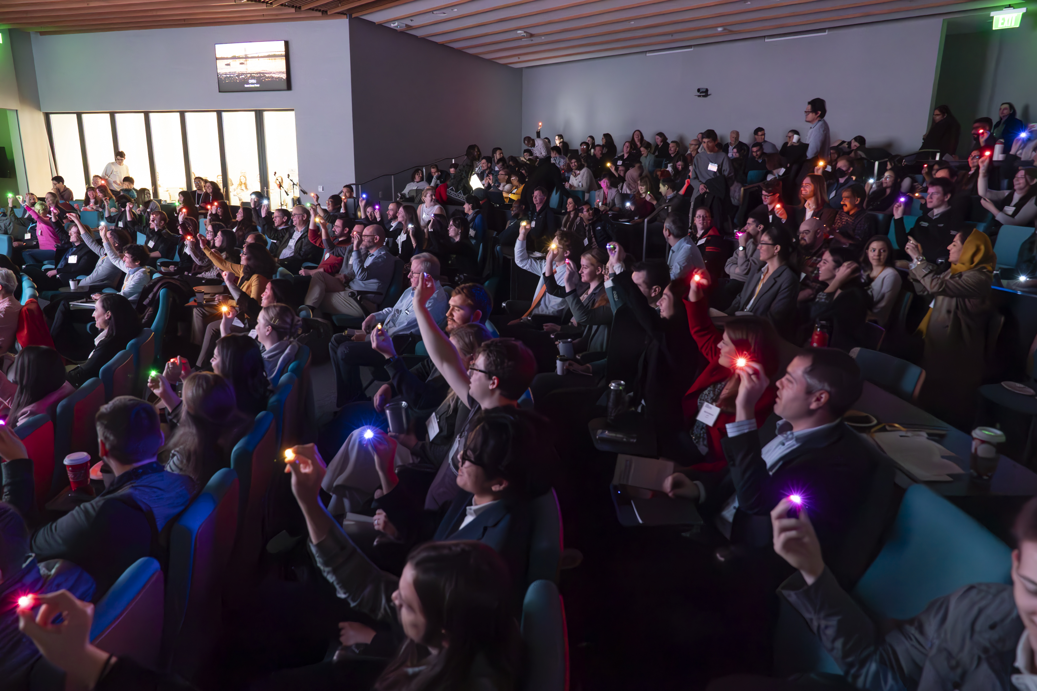 Oregon Bioengineering Symposium: Auditorium filled with conference attendees holding up small multi-colored lights