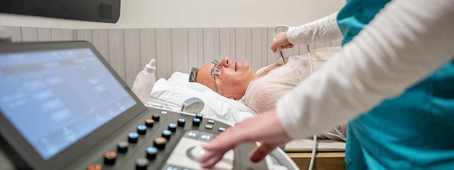 A medical professional examines a patient’s heart with an ultrasound machine.