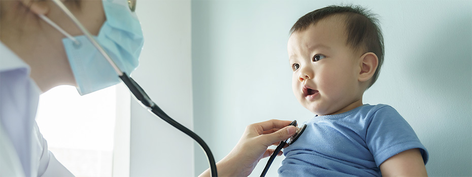 An OHSU nursing student using a stethoscope to check a toddler’s heartbeat.